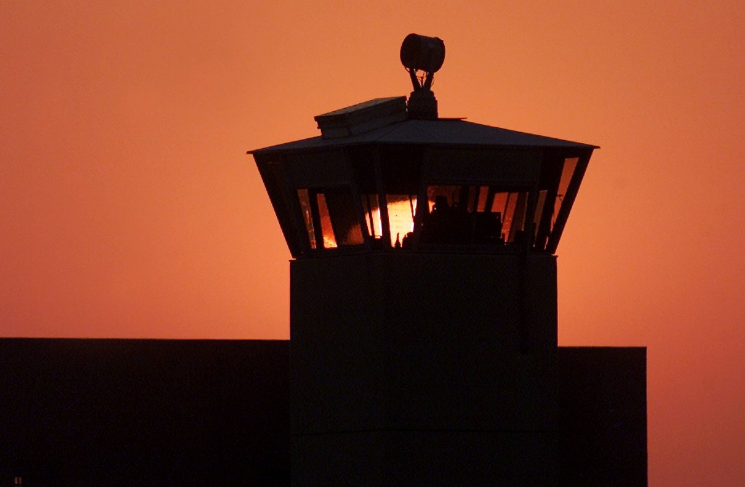 The sun sets behind one of the guard towers at the Federal Correctional Complex in Terre Haute, Ind., June 10, 2001. The death chamber at the correctional facility is where the federal death penalty is carried out.